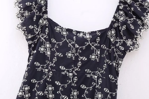 Detail of square neckline with white floral embroidery on navy blue cotton dress