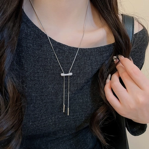 Détail d'un collier nœud en argent serti de zircons avec de longs pendentifs verticaux