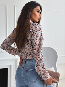 Detail view of floral print long sleeve shirt paired with light blue jeans and chain bag