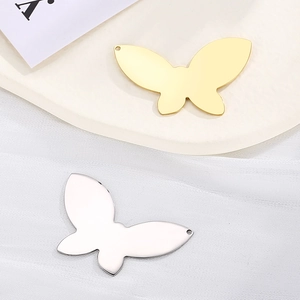 Mirror-polished stainless steel butterfly pendants in gold and silver finish on tray