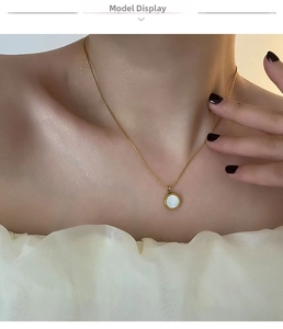 Close-up of 18K gold-plated titanium necklace with white mother of pearl pendant on model