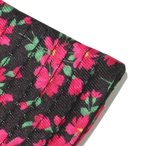Close-up of sun hat fabric showing pink floral patterns and woven texture detail