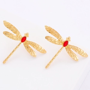 Détail de boucles d'oreilles libellule dorées avec pierres marquise rouges et ailes