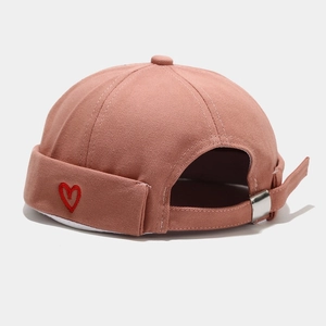Detailed close-up of pink cotton docker hat with red heart embroidery and strap