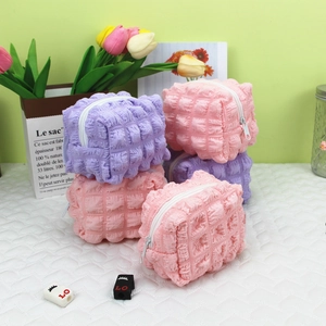 Detailed view of puff quilted small organizers in pink and purple with zipper closure