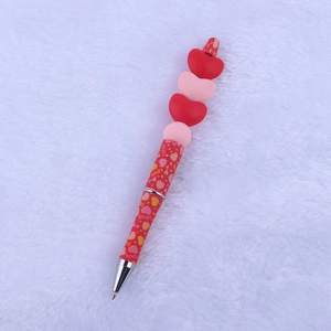 Detail of red cartoon Valentine heart silicone beaded pen with stacked hearts and LOVE print