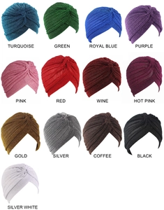 Detail showing 13 vibrant metallic colors of pleated turban hats on a white background