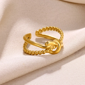 Macro shot of 18k gold plated knotted open ring with smooth and beaded texture