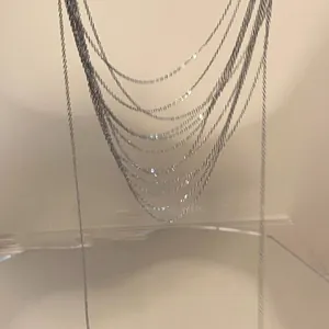 Artistic detail of silver layered necklaces showing delicate tassel chains on display