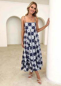 Detail of square neck summer dress with navy gingham and palm tree patterns on long skirt