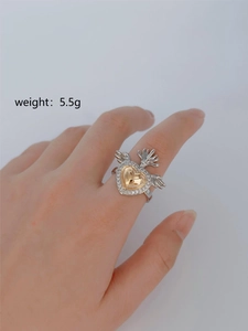Detailed view of a 5.5g gothic wing ring with a golden heart and zircon pavé detail