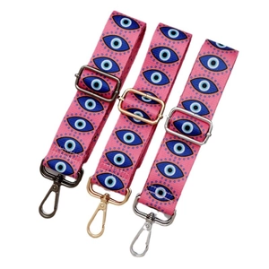 Adjustable nylon shoulder straps with evil eye patterns in gold, silver, and black hardware
