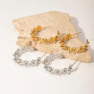 Pendientes de aro en forma de C con flores de margarita en oro y plata sobre piedra