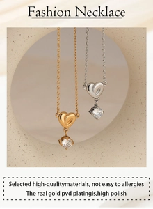 Vertical hanging gold and silver heart zircon necklaces shown in a minimalist setting