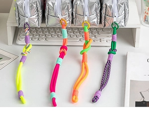 Detail of colorful woven rope zipper pulls on silver quilted stationery pouches