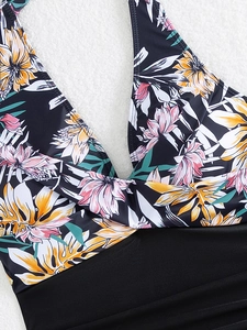 Close-up of tropical floral print halter swimsuit with twist-front detail on white rug