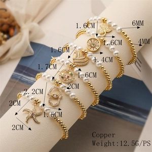 Détail de bracelets en cuivre superposés avec breloques en zircon et perles sur présentoir