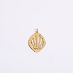 Macro view of gold plated shield pendant with zircon eyes and hollow metal design