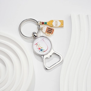 Macro view of silver bottle opener keychain with letter J pendant and beer charms