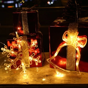 Festive LED suction cup lights in snowflake and bell shapes with warm yellow glow