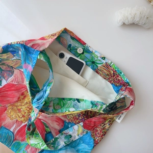 Detail view of cotton tote bag interior with magnetic snap and pocket holding a phone