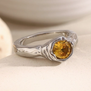 Macro shot of 18K gold plated stainless steel ring with yellow zircon and lava texture