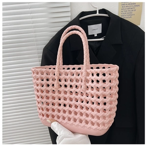 Detailed view of a pink woven hollow jelly beach bag with durable handles for summer