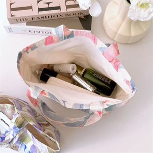 Top view of open tulip canvas tote bag showing interior space with cosmetics