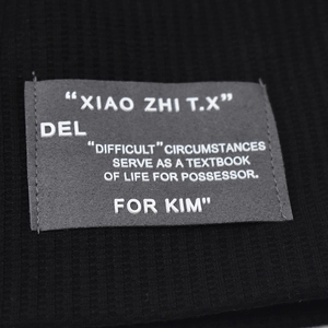 Knitted slouchy beanie in black with rectangular textile logo label and white lettering
