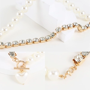 Detailed view of the gold heart pearl pendant with rhinestone chain and OT toggle clasp