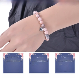 Close-up of 8mm pink zebra stone bracelet with heart pendant and gift message cards