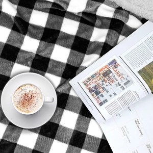Detail of checkered sherpa blanket texture with coffee and magazine for a cozy lifestyle