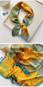 Detailed macro view showing the glossy satin texture and abstract art print of the silk scarf