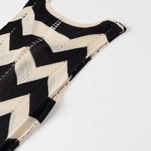 Detailaufnahme des schwarz-beigen Zickzack-Strickmusters und der Trägerstruktur des Kleids
