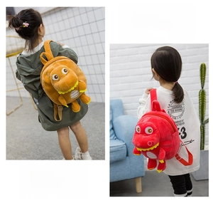 Detail showing red and orange plush dinosaur backpacks for kids with 3D stuffed heads