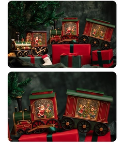 Close-up of festive Santa train snow globe with detailed red gift box and Christmas tree
