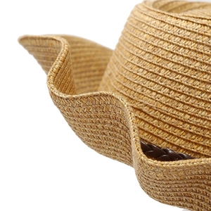 Macro detail of hand-woven straw hat with wavy brim and brown decorative leather band