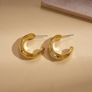 Detail of 18K gold plated C-shape hoop earrings with irregular fluid wave texture