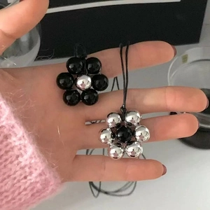 Minimalist black onyx beaded flower pendant necklaces shown in two color variations