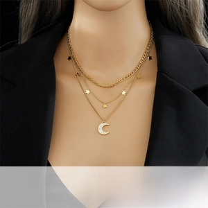 Close-up of triple-layered gold titanium steel necklace with star and moon charms