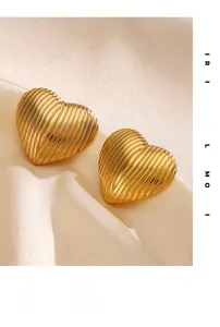 Macro view of gold heart stud earrings with vertical textured stripes on silk background