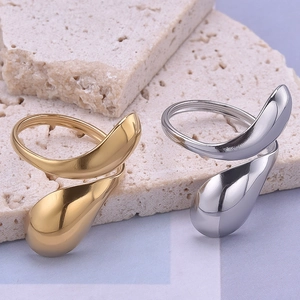 Irregular waterdrop open rings in gold and silver finish on a natural textured stone