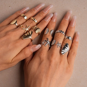Close-up of a 6-piece ocean-themed starfish and seashell ring set on a hand