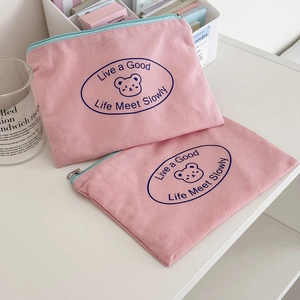 Detail of pink canvas zipper pouches with cute bear print and soft aesthetic design