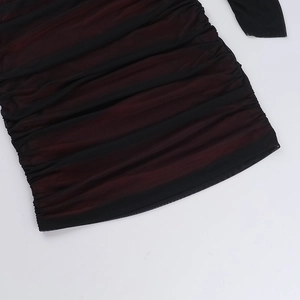 Détail de robe en maille rouge et noire montrant des plis et une texture froncée