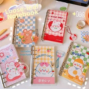 Detailed top view of five colorful loose-leaf binders with cute animal acrylic pendants
