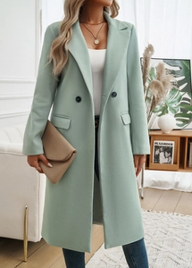 Detail of light green double-breasted coat with lapel collar and beige clutch bag