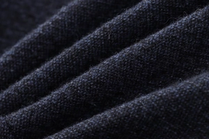 Gros plan sur la texture du tissu bleu marine montrant le tissage fin et les fibres