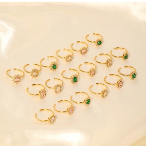 Detailed macro view of adjustable gold rings with vibrant emerald and pink zircon stones