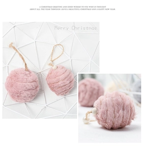 Detailed view of a soft pink fuzzy felt ball ornament with a white pearl and jute string